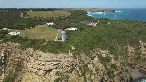 Flying away from Cape Schanck Lighthouse over rugged coastline into open ocean. Mornington Peninsula, Melbourne, Australia.