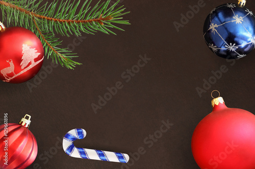 Dark background with Christmas fir branch, stick, red wavy dull and blue ball photo