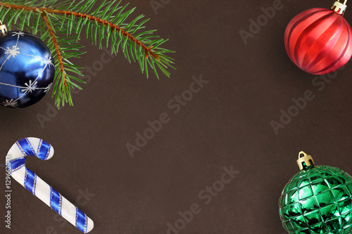 Dark background with Christmas fir branch, stick, blue, green ribbed and red wavy ball photo