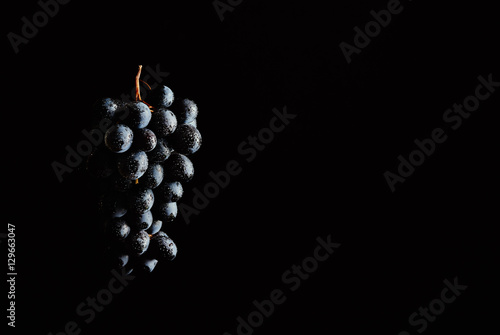 Bunch of red wine grapes on a black background