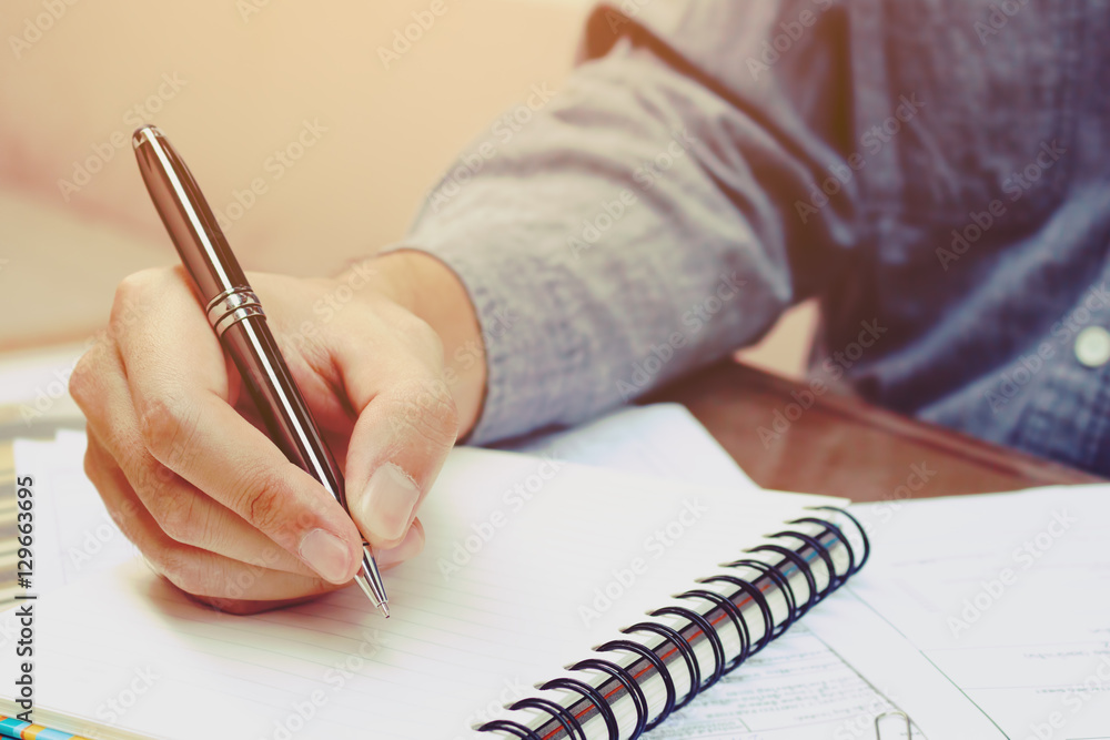 Young asian man writing form filling with register on paper note Young asian man writing form filling with register on paper note