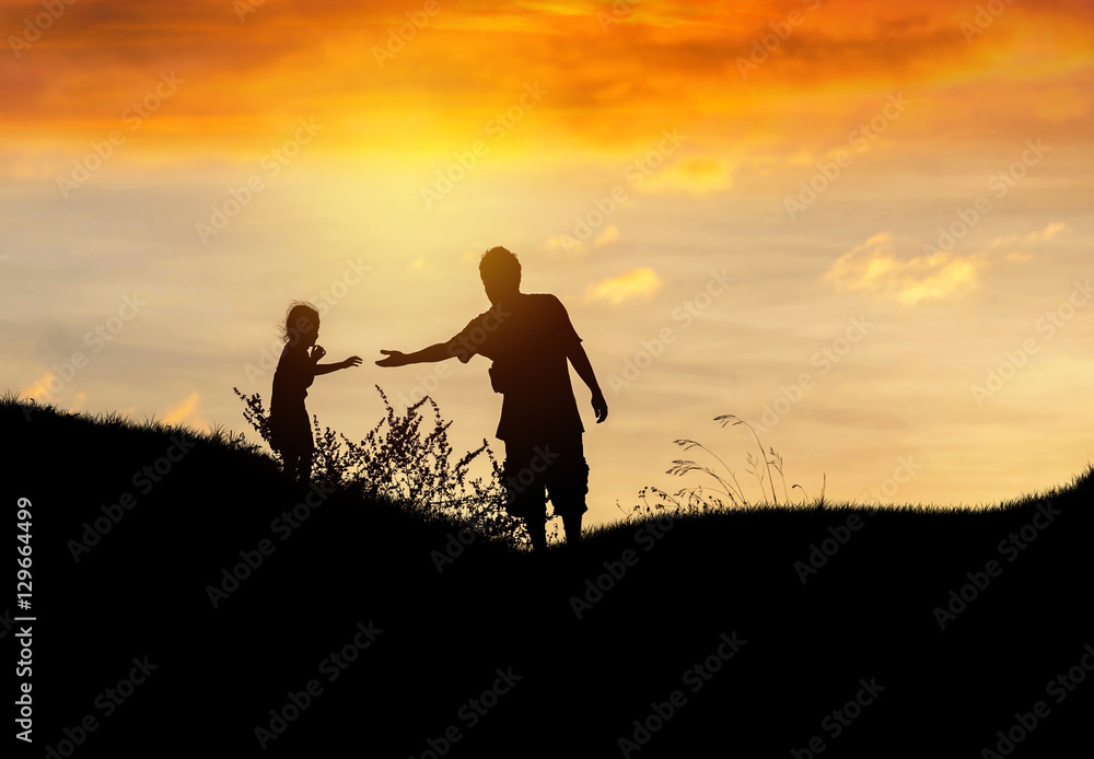Silhouette father stretch hand helping to daughter on sunset
