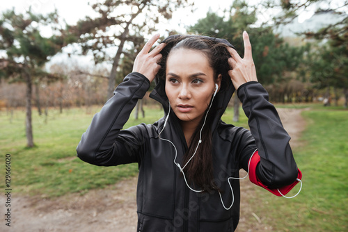 Beautiful lady runner in warm clothes looking aside © Drobot Dean