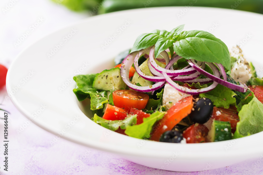 Greek salad with fresh tomato, cucumber, red onion, basil, lettuce, feta cheese, black olives and Italian herbs Greek salad with fresh tomato, cucumber, red onion, basil, lettuce, feta cheese, black olives and Italian herbs