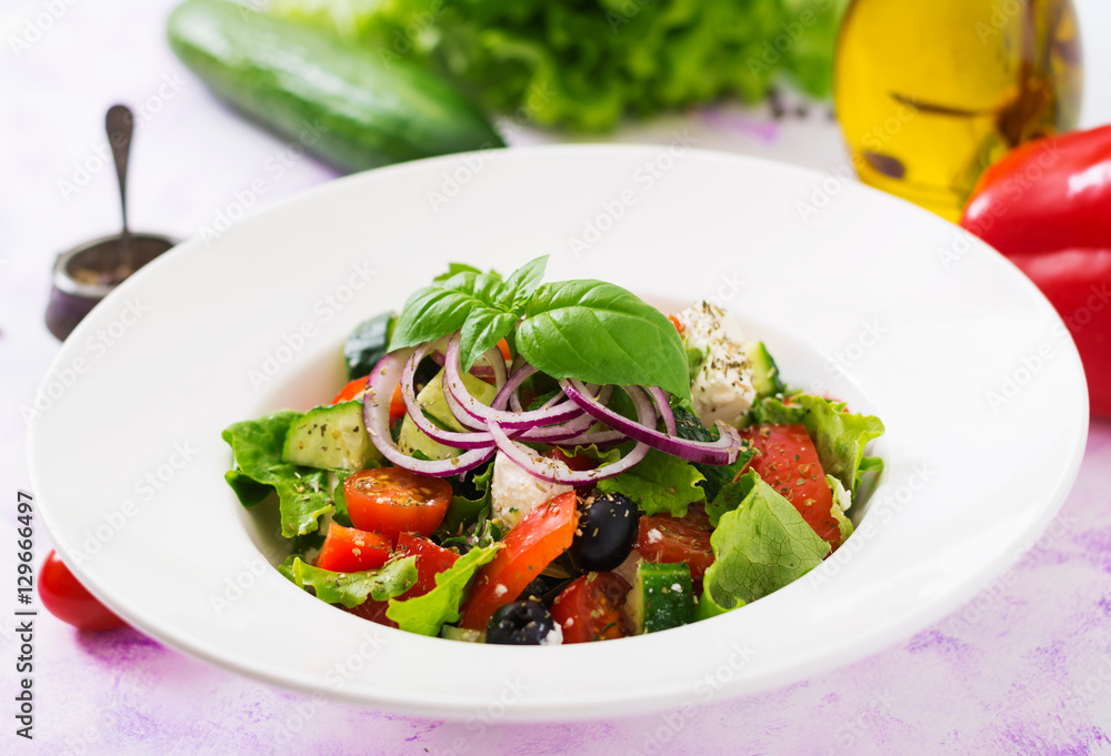 Greek salad with fresh tomato, cucumber, red onion, basil, lettuce, feta cheese, black olives and Italian herbs Greek salad with fresh tomato, cucumber, red onion, basil, lettuce, feta cheese, black olives and Italian herbs