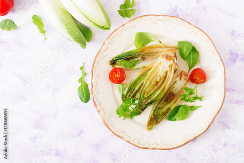 Картината върху платно Baked chicory with onions and herbs. Top view