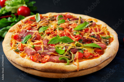 Pizza with salami, ham, tomato, cheese and mushrooms