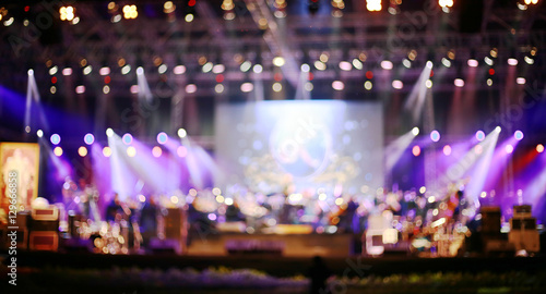 Blurred background : Bokeh lighting in concert with audience ,Music showbiz concept, music performance concert with bokeh spotlight. entertainment concert lighting on stage, blurred disco party.