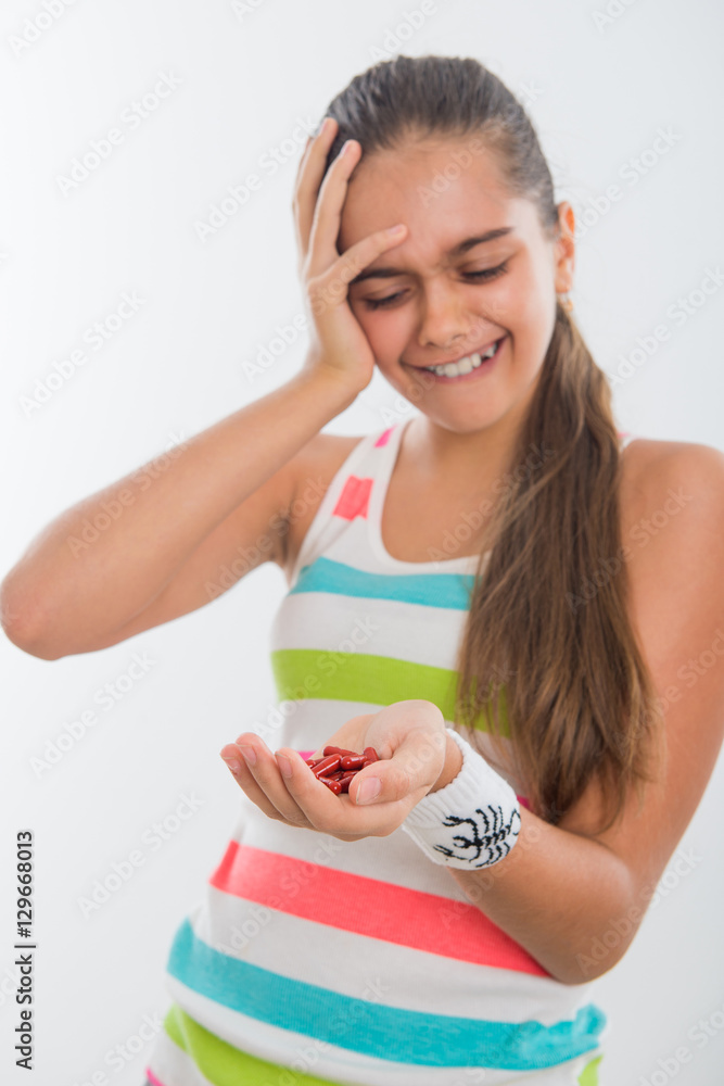 young girl holding a tablet, girl suffering from pain. sport, healthy lifestyle, medicine, nutritional supplements and people concept. Tablets for treatment sports diseases, pain pills
