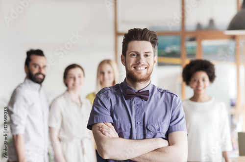 happy young man over creative team in office