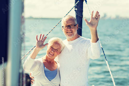 senior couple hugging on sail boat or yacht in sea