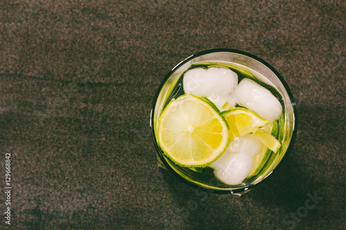 alcoholic cocktail with green lemon and ice close-up view from above, toning photo photo