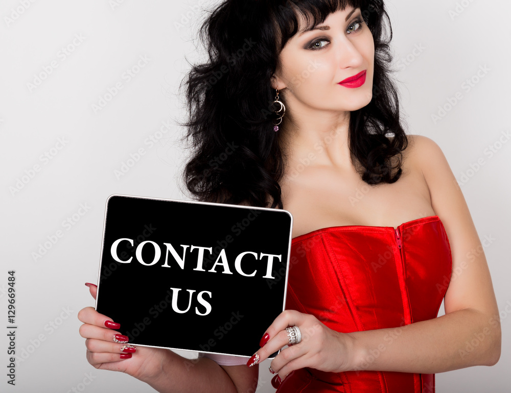 contact us written on virtual screen. technology, internet and networking concept. sexy woman in a red corset holding pc tablet contact us written on virtual screen. technology, internet and networking concept. sexy woman in a red corset holding pc tablet