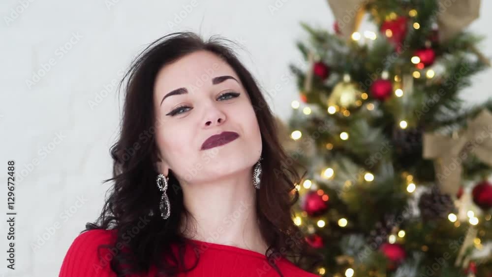 Beautiful Girl Smiling While Standing Near the Christmas Tree. New Year. She is Very Beautiful and Attractive. Beautiful Girl Smiling While Standing Near the Christmas Tree. New Year. She is Very Beautiful and Attractive.