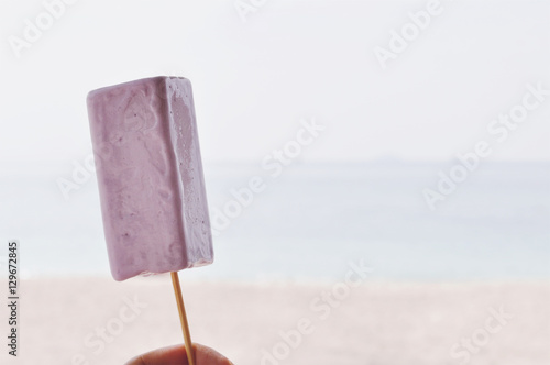 Hand Holding Taro Icecream On Beach Background