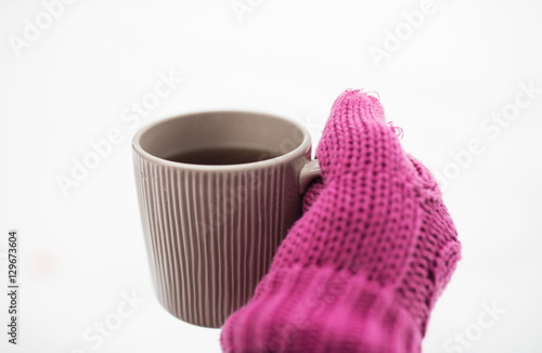 close up of hand in winter mitten holding tea mug