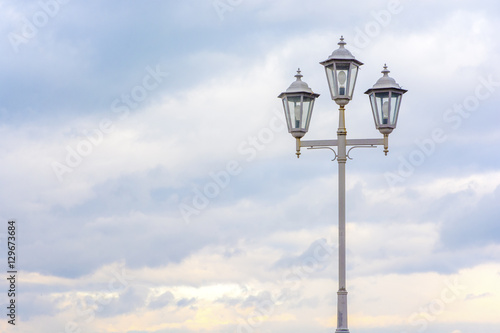 Old street lamp on a background of cloudy sky. Soft colors. Beautiful background.