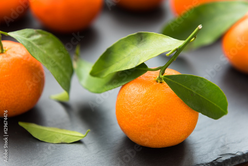 Ripe mandarin with leaves on a table