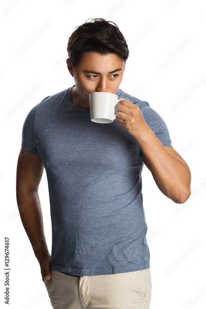 Smiling mature man wearing a blue t-shirt and beige pants, standing against a white background holding a mug. Smiling mature man wearing a blue t-shirt and beige pants, standing against a white background holding a mug.