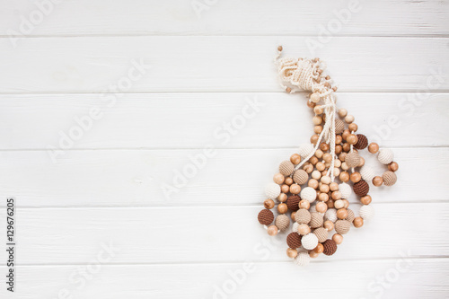 Knitted beads necklace on white wooden backroung