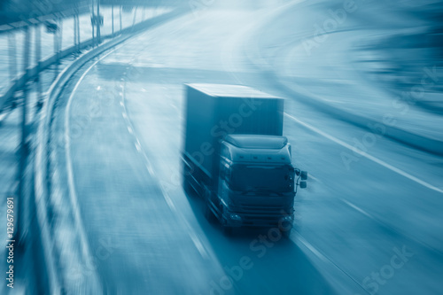 Motion blurred trucks on highway. Transportation industry metaphor