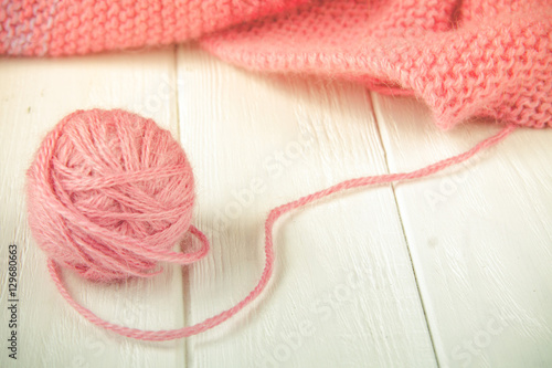 Knitting yarn rolled into ball on a white wooden background.