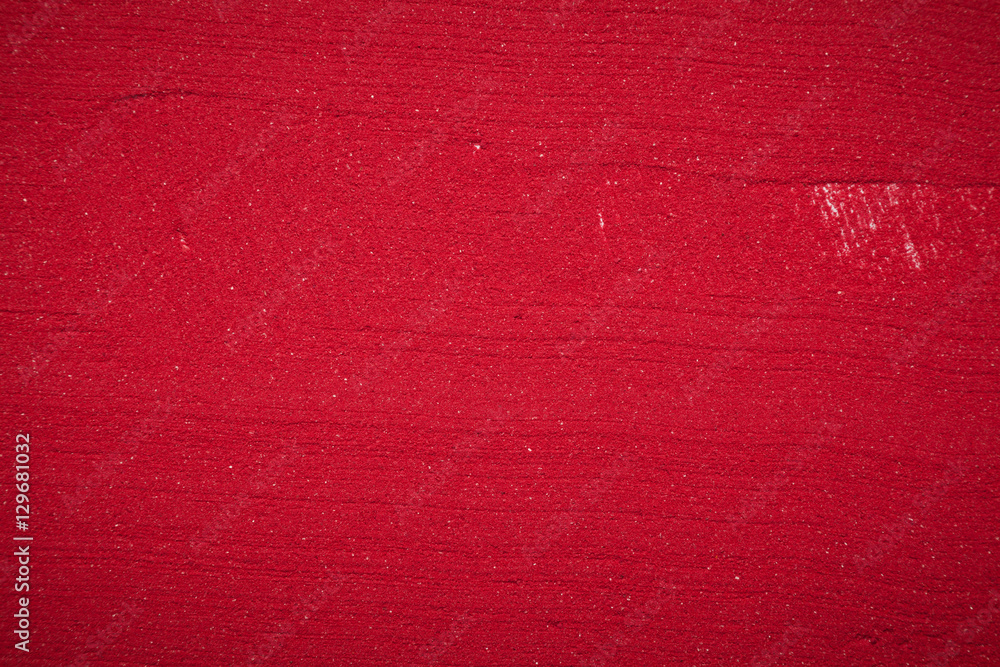 Fototapeta premium Close up plane background texture of solid red color made of soil.