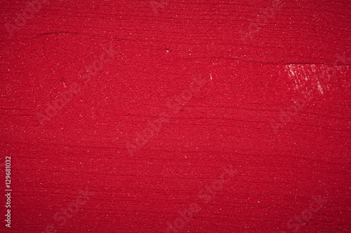 Close up plane background texture of solid red color made of soil. photo