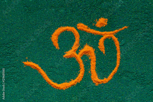 Top view of colorful Om rangoli symbol made of soil colors isolated on white background.