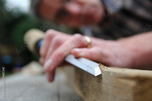 Traditional woodworker using wooden mallet and chisel