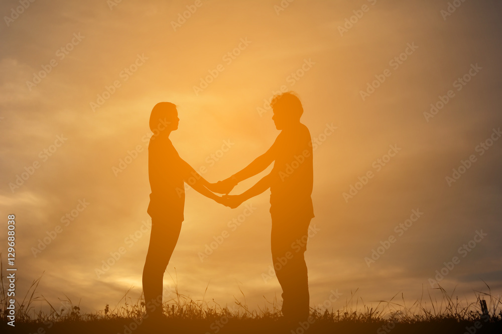 Silhouette women and man of lovers at the sky sunset, concept valentine day color of vintage tone