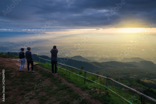 Tourists photograph the sunrise on a mountains.