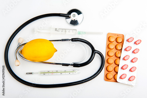 Stethoscope and medicine on white background