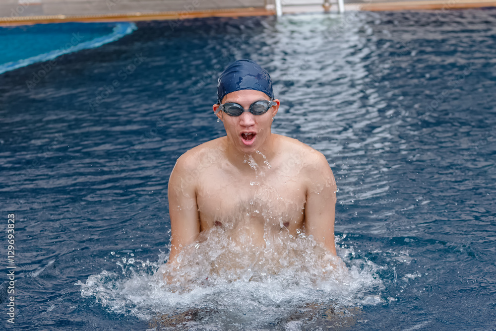 young man finishing swimming training, getting out of pool