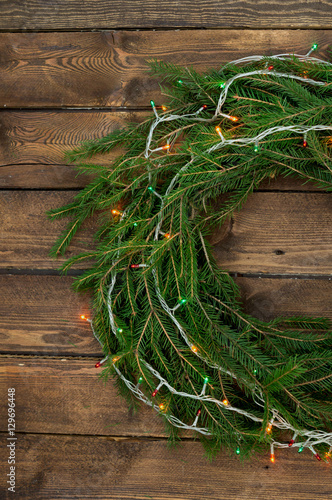 Christmas wreath of tree branches on wooden background