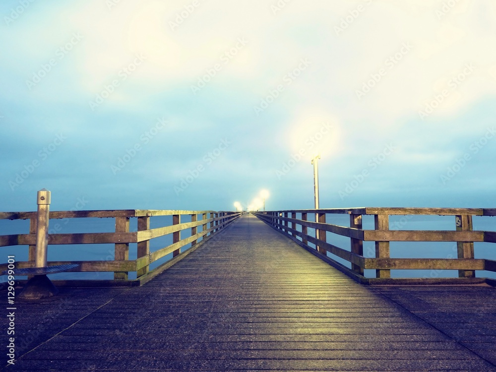 Autumn dark mist on wooden pier above sea. Depression, dark atmosphere.