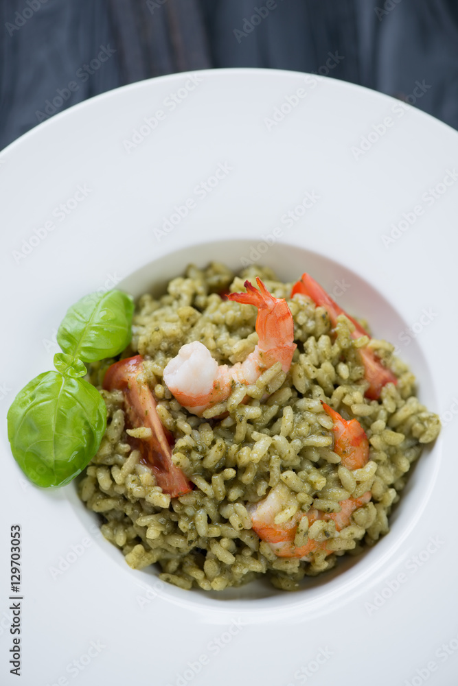Closeup of spinach risotto with tomatoes and tiger shrimps Closeup of spinach risotto with tomatoes and tiger shrimps