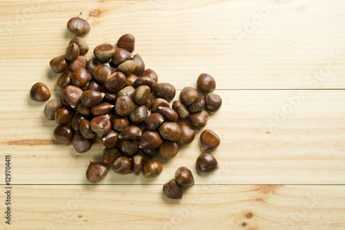 Chestnuts on pine wood background.