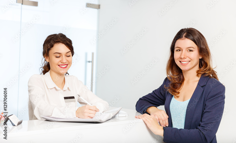 friendly woman behind reception desk administrator with customer friendly woman behind reception desk administrator with customer