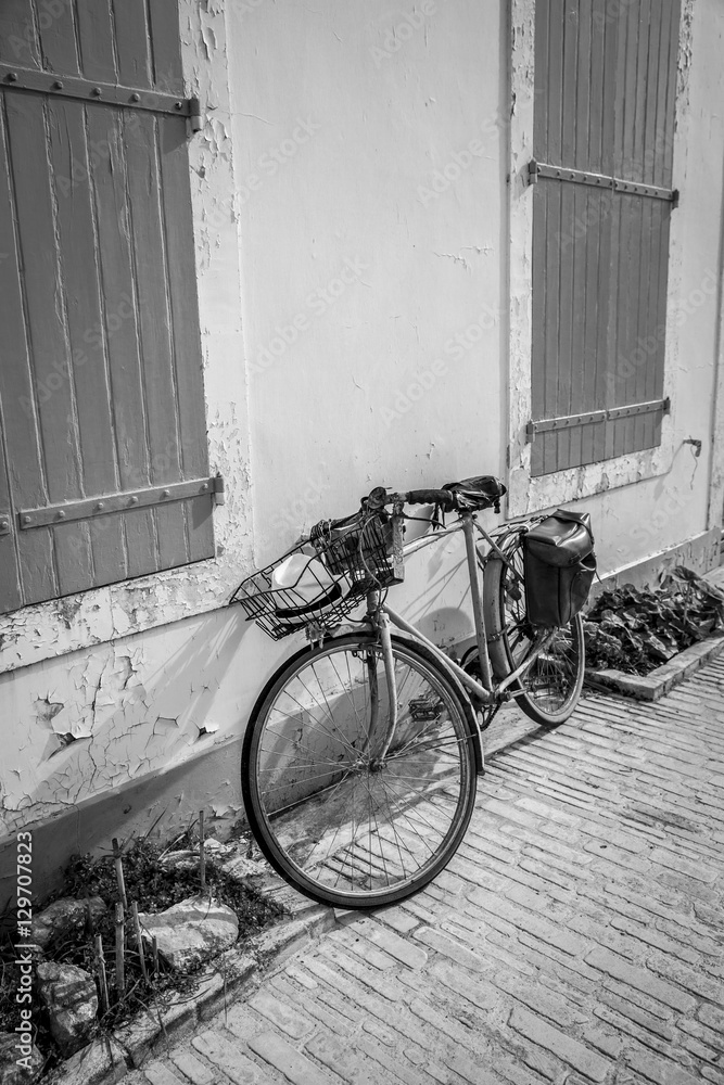 Black and white view of seaside holidays house with wooden shutters with a bike in front Black and white view of seaside holidays house with wooden shutters with a bike in front