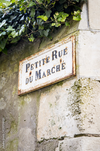 Old French street sign Petite Rue Du Marche or Market alley on an old limestone wall, Ile de Re, France