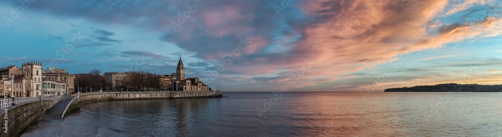 San Pedro church in San Lorenzo beach in Gijon in Asturias natural paradise travel touristic destination for vacations in Spain at dawn before sunrise. Panorama with calm sea landscape background.