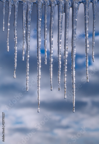 Winter icicles against the background of the cloudy sky
