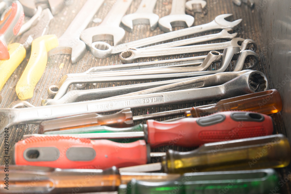 Fototapeta premium Work tools in a car garage vehicle repair. screwdriver for car fix on duty. Set of tolls in a case. Close up