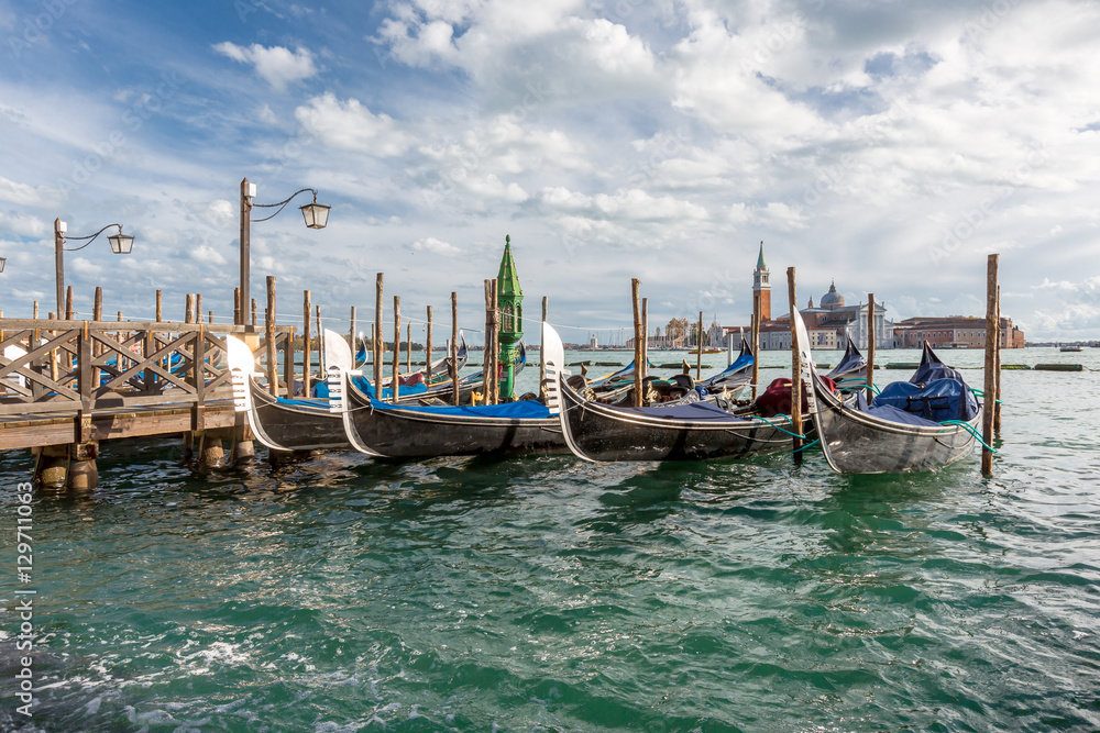 Group of gondolas docked on the water.