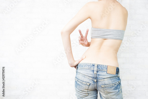 Plakat w ramie ブイサインをする女性の後姿