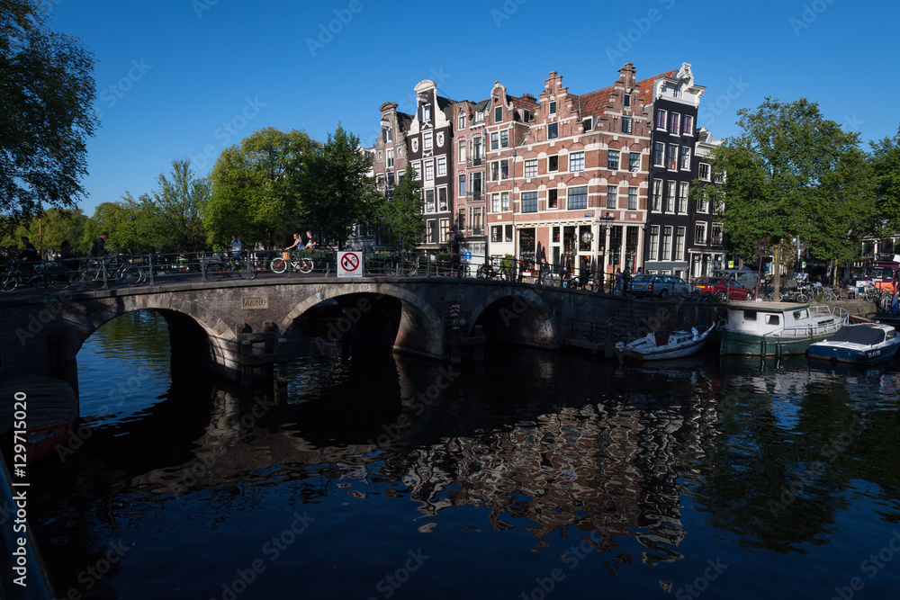 Naklejka premium Crooked buildings in the early morning summer sun on the corner of the Browersgracht and Prinsengracht, Amsterdam, Netherlands