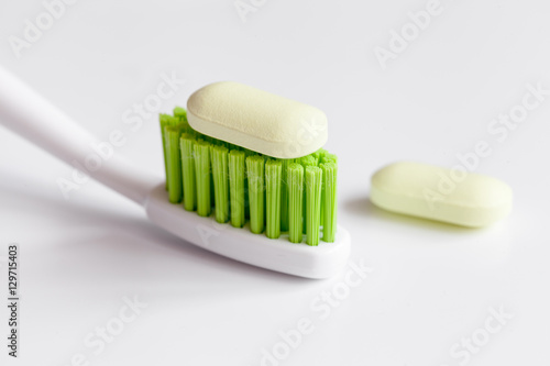 concept toothache with toothbrush and pills at white background