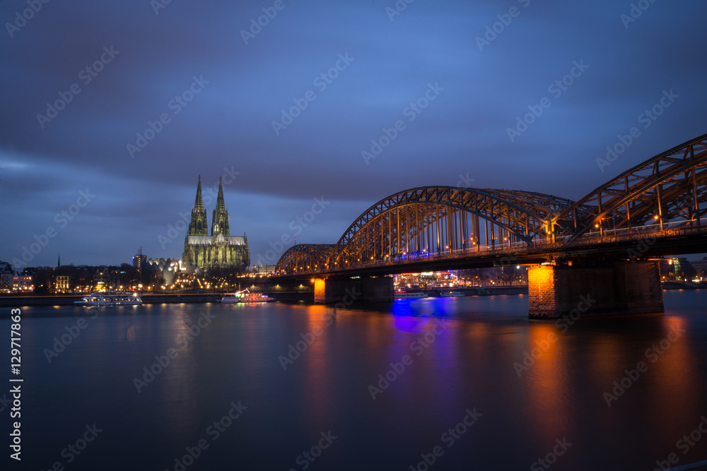 Obraz premium Cologne Cathedral and Hohenzollern Bridge at sunset / nighttime