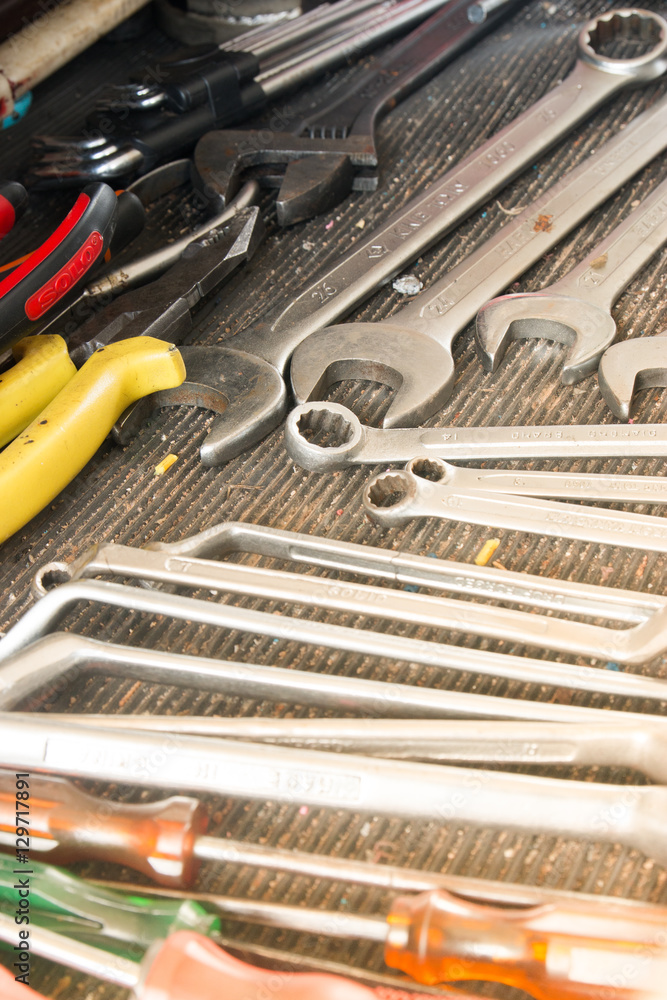 Fototapeta premium Work tools in a car garage vehicle repair. screwdriver for car fix on duty. Set of tolls in a case. Close up